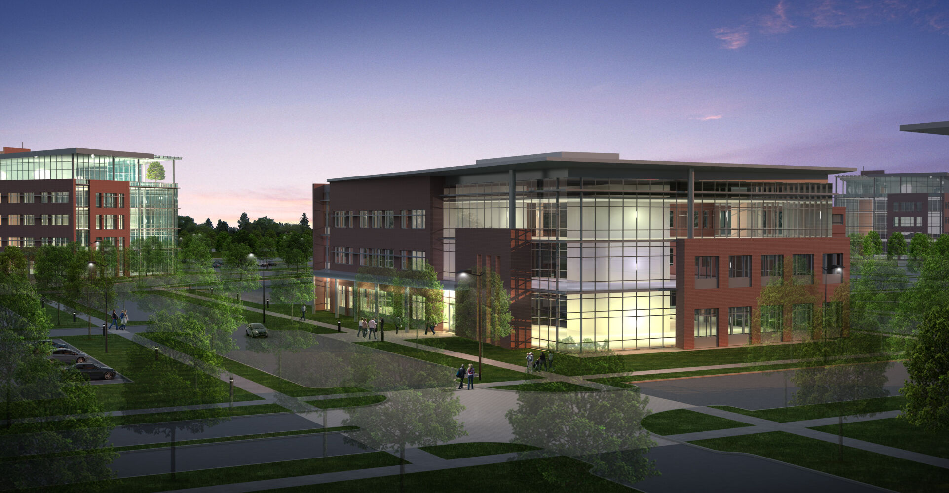 multi‑story office building featuring brick and glass exterior, shown at dusk with interior lights glowing