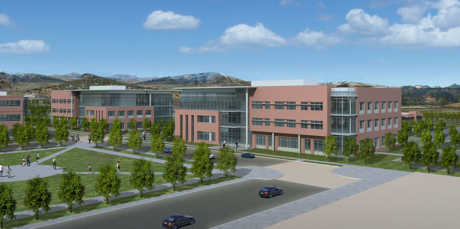 office campus with brick and glass buildings arranged around landscaped open space and pedestrian paths