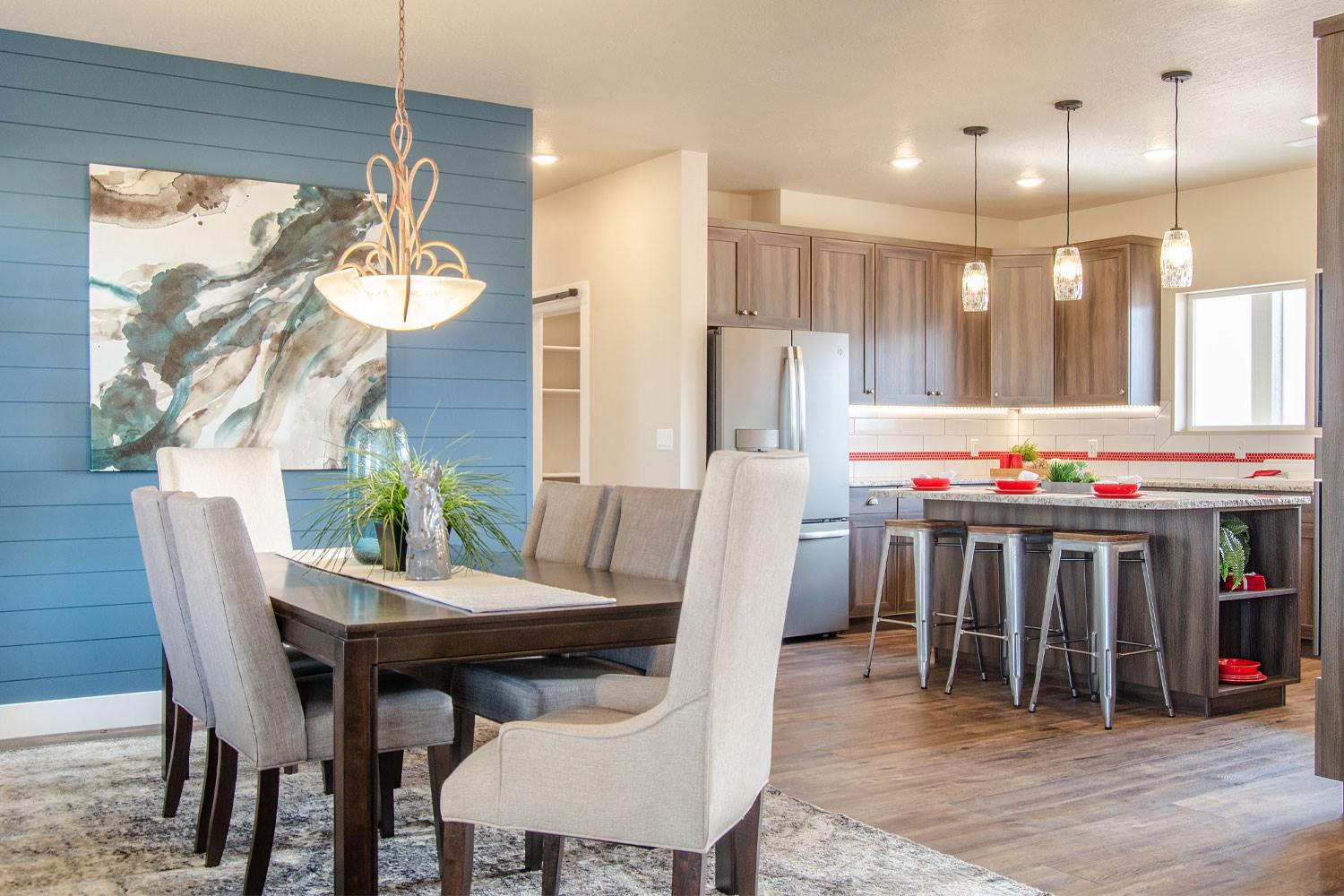 open floor plan showing smooth dark brown wood dining table with six upholstered chairs and kitchen in the background 