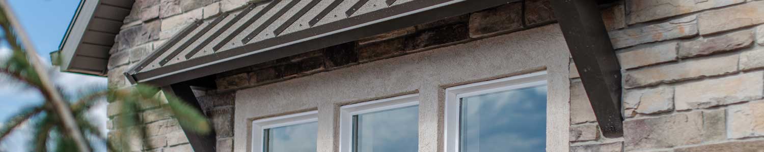 stone siding garage with three windows and awning built to park RV