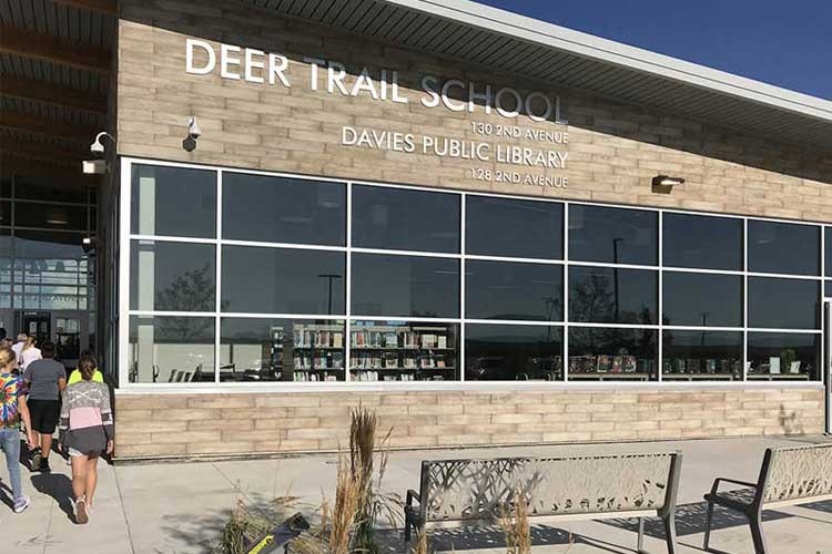 Group of students walking into the entrance of the Deer Trail School Library