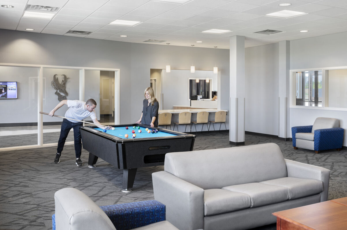 Student commons at Gillette College with a pool table, soft seating, and adjacent study counters.