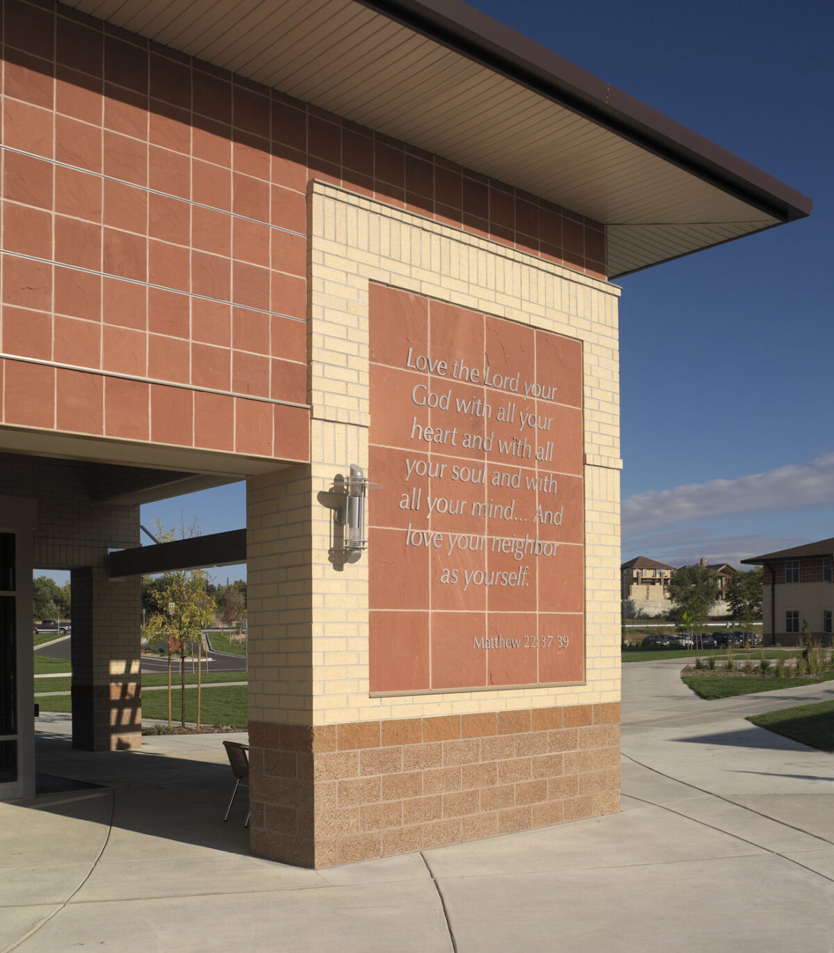 Denver Seminary campus building with a brick and tile façade featuring an engraved scripture panel near the main entry.