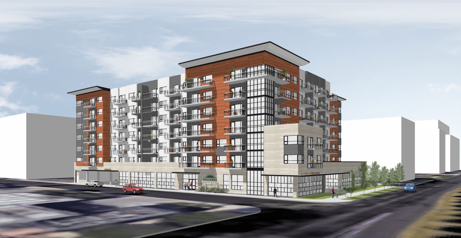 Architectural rendering of a multi‑story age in place residential building with red and gray façades, large balconies, and a glass‑fronted ground level located at a street intersection.