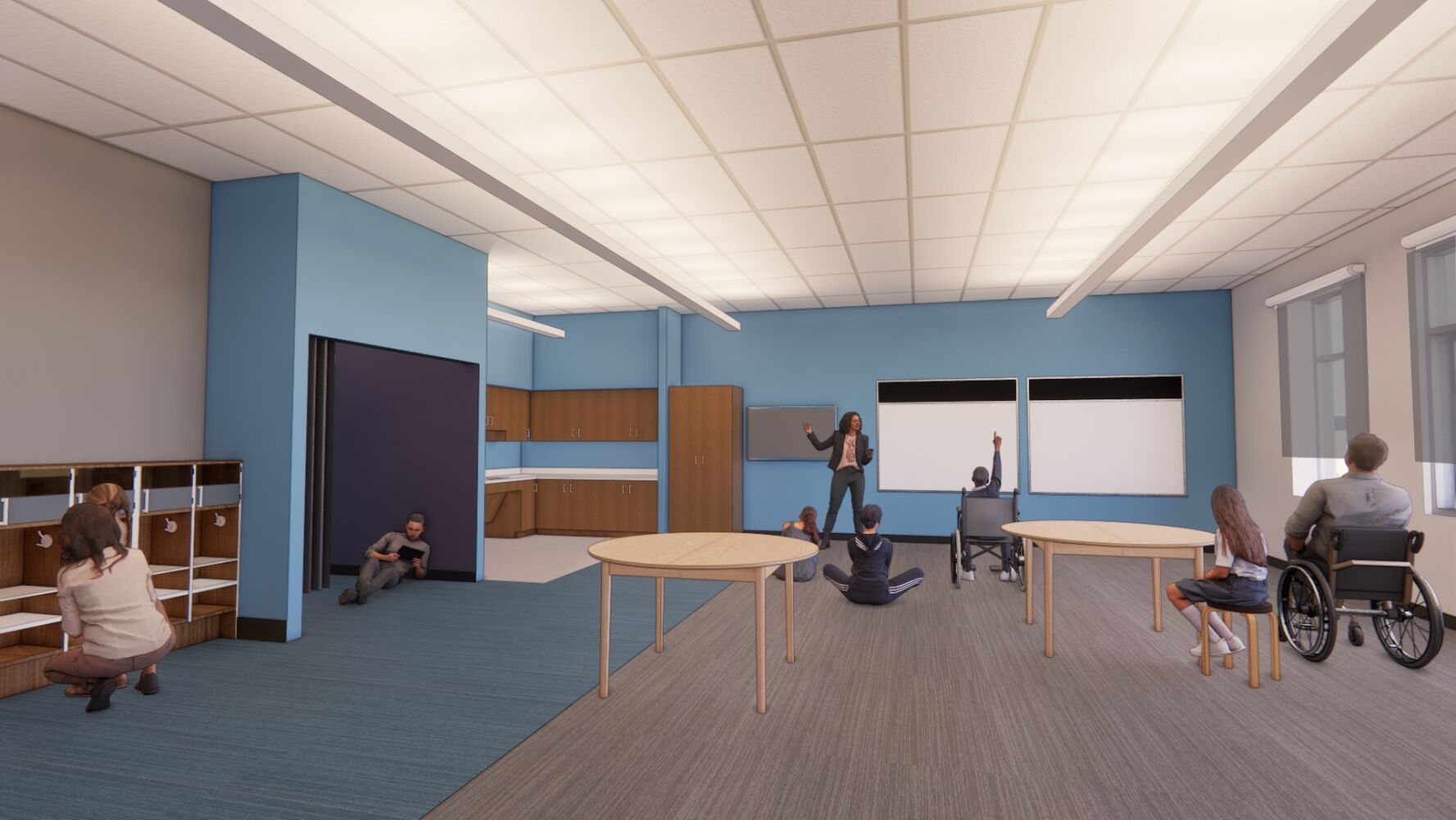 Classroom with blue accent walls, built‑in shelving, round activity tables, wood‑look cabinetry, dual wall‑mounted display boards, and a suspended ceiling with integrated lighting.
