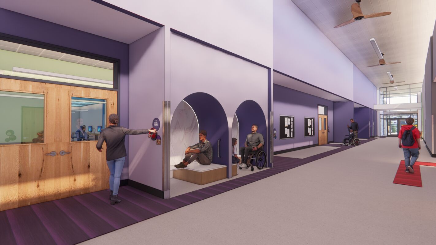 Corridor with purple accent walls, arched alcoves with built‑in benches, classroom doors with sidelights, display boards, and a high ceiling with linear lighting and large ceiling fans.