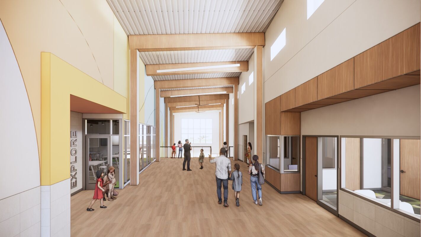 Main hall with exposed wood beams, clerestory windows, wood wall accents, large glass panels, and a light wood floor.