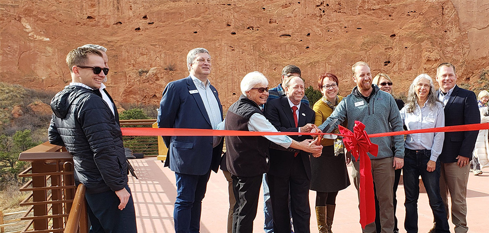 a group prepares to cut the ribbon at the garden of the gods restrooms ribbon cutting