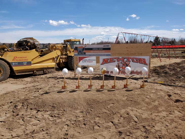 shovels with hard hats on top in the ground at a construction site