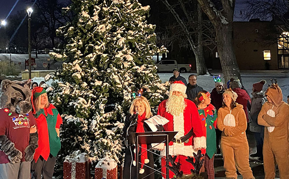 group in front of a christmas tree in festive attire