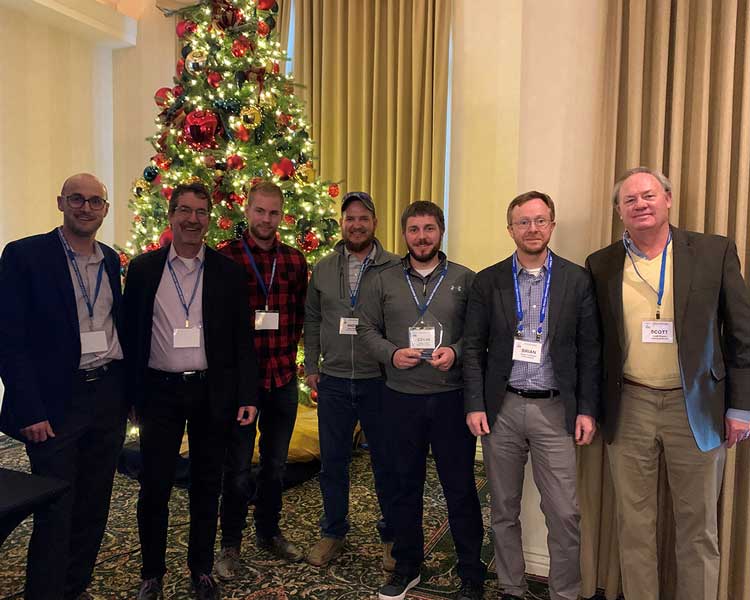 a group in front of a christmas tree at the DBIA awards