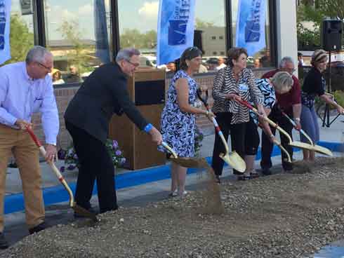 a group of people participate in the groundbreaking ceremony