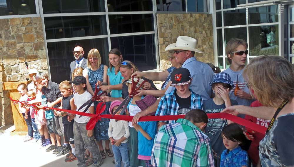 students and staff prepare to cut the ribbon at the ribbon cutting ceremony