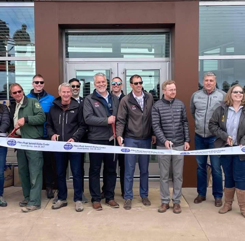 a group of people prepare to cut the ribbon for the Pikes Peak Summit Visitor Center