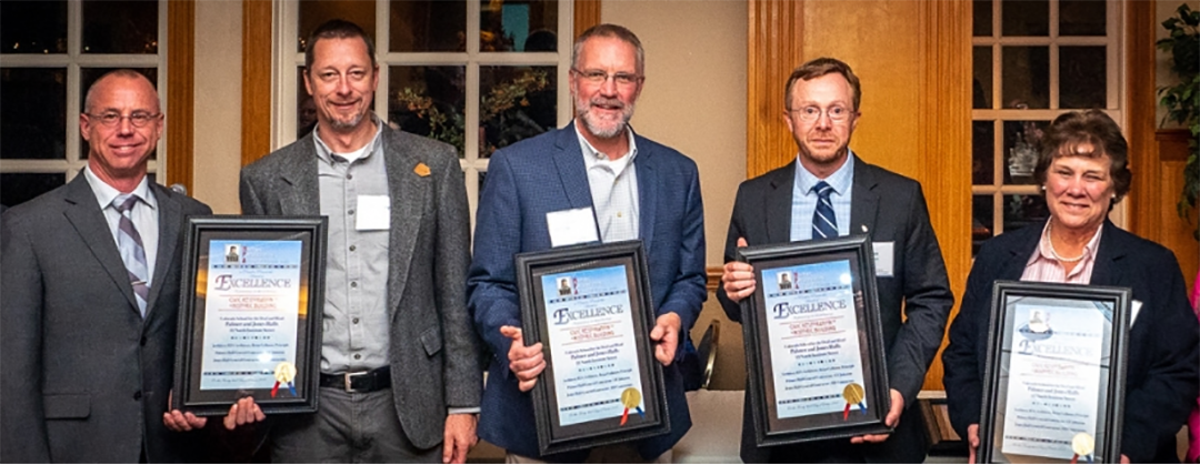 group holding framed awards for Jones and Palmer Hall