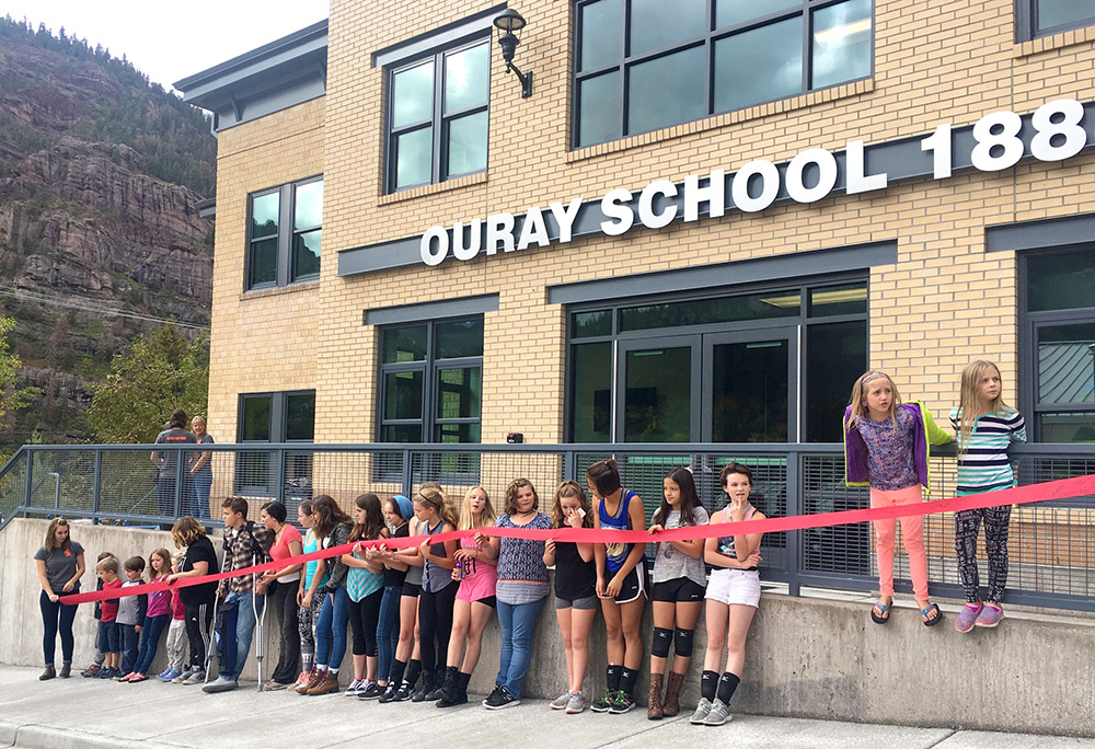 students standing alongside the ribbon cutting