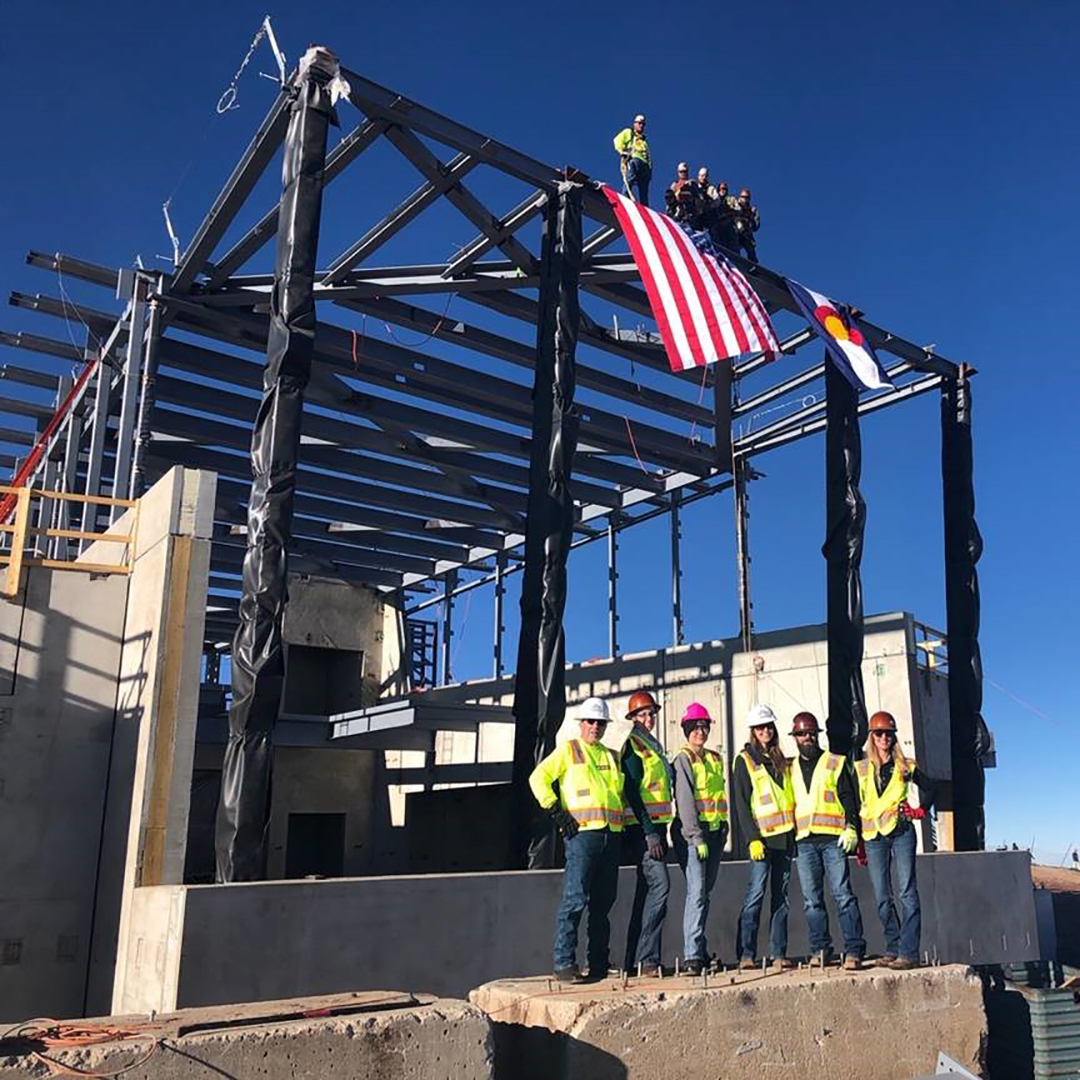 group of people in front of the steel structure of the new visitor center